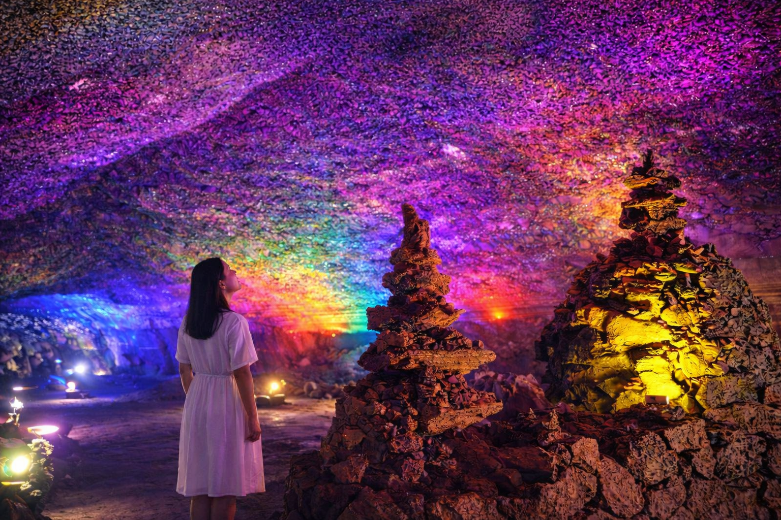 Inside a lava cave lit with colorful lights